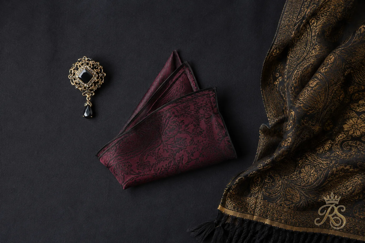 Flatlay of groom bandhgala accessories including a collar brooch, pocket square, and stole