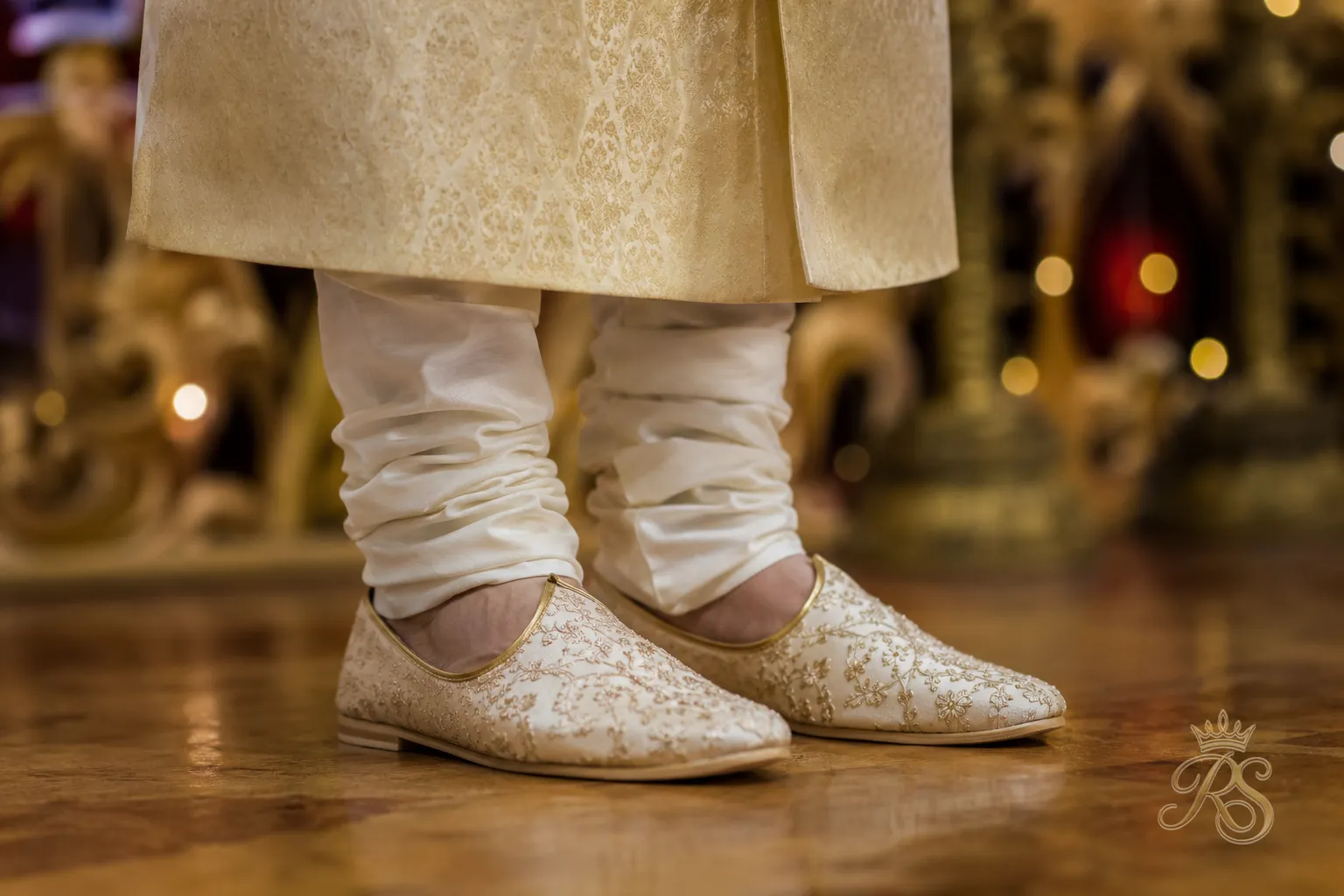 Close-up of embroidered juttis paired with a bandhgala jacket and churidar