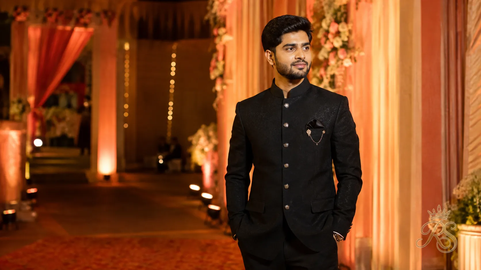 Groom in a tailored black bandhgala jacket posing at his wedding