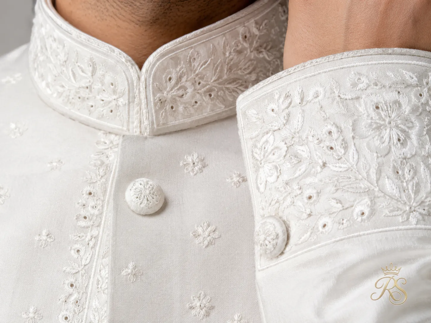 Close-up of chikankari embroidery on white sherwani collar and cuff