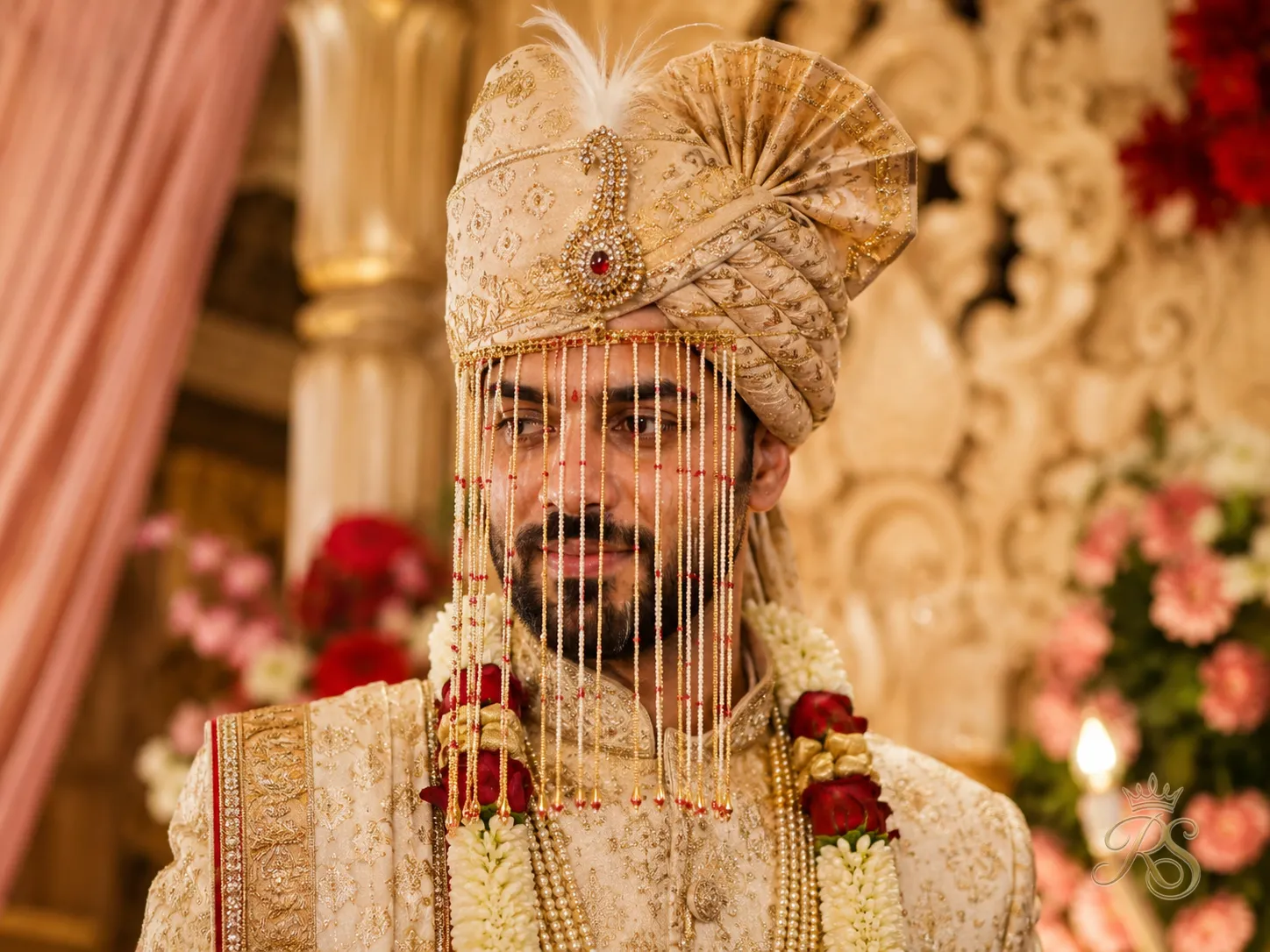Indian groom in a gold-embroidered safa turban with brooch and sehra for wedding ceremony