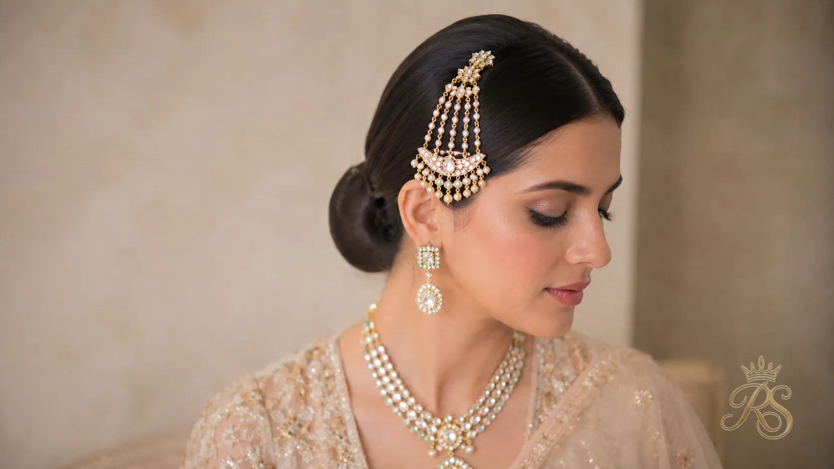 Bride with a sleek low chignon hairstyle adorned with a jhoomar for her wedding