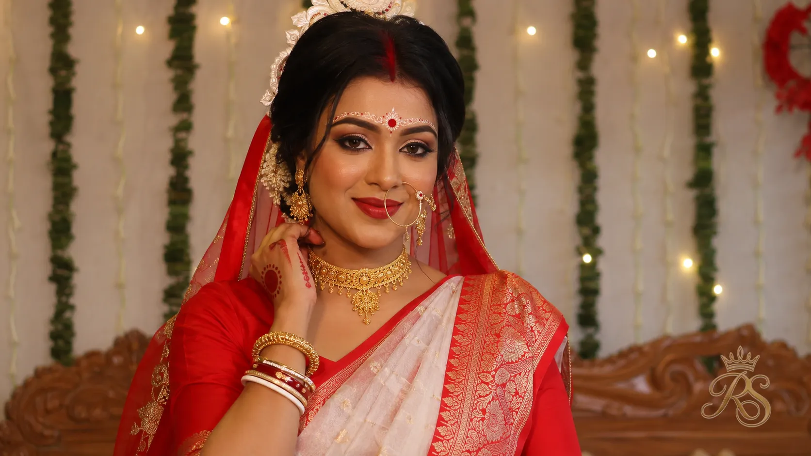 Bengali bride wearing traditional gold jewellery including a shakha pola and elaborate choker