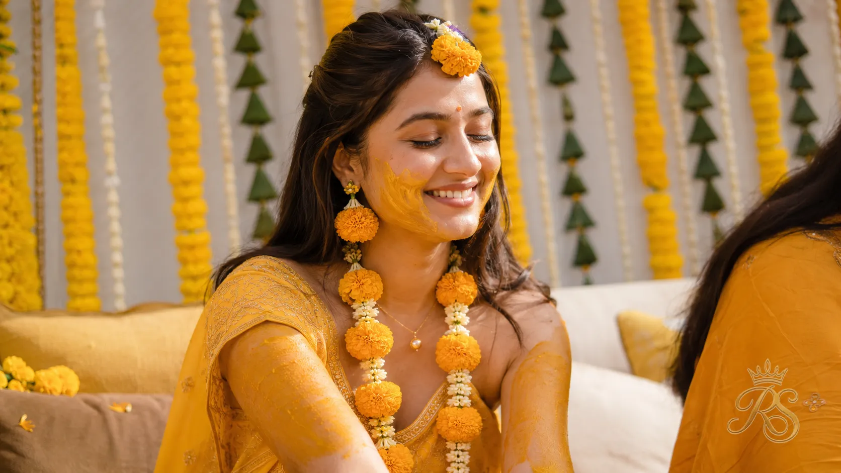 Bride at haldi ceremony wearing simple marigold and gold jewellery