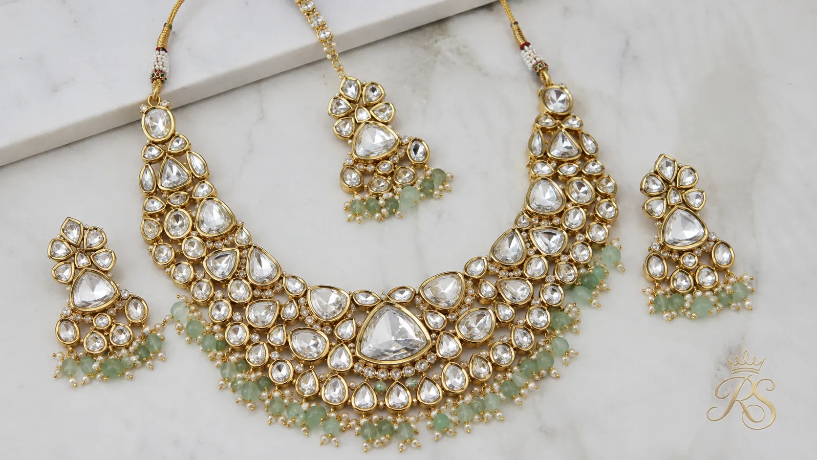 Uncut polki diamond bridal necklace set on a white background