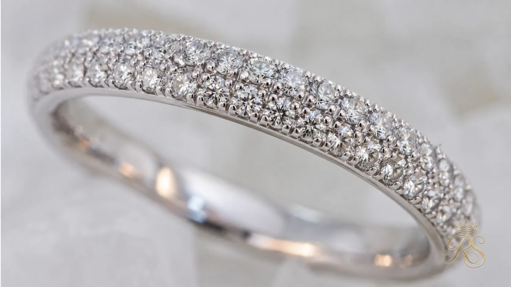 Pave band engagement ring with a row of tiny diamonds set into the band