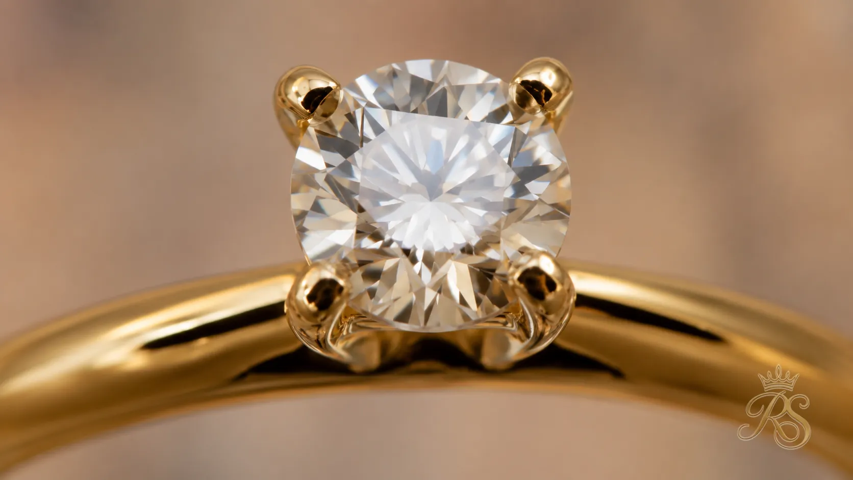 Close-up of a four-prong setting holding a round diamond securely above the band