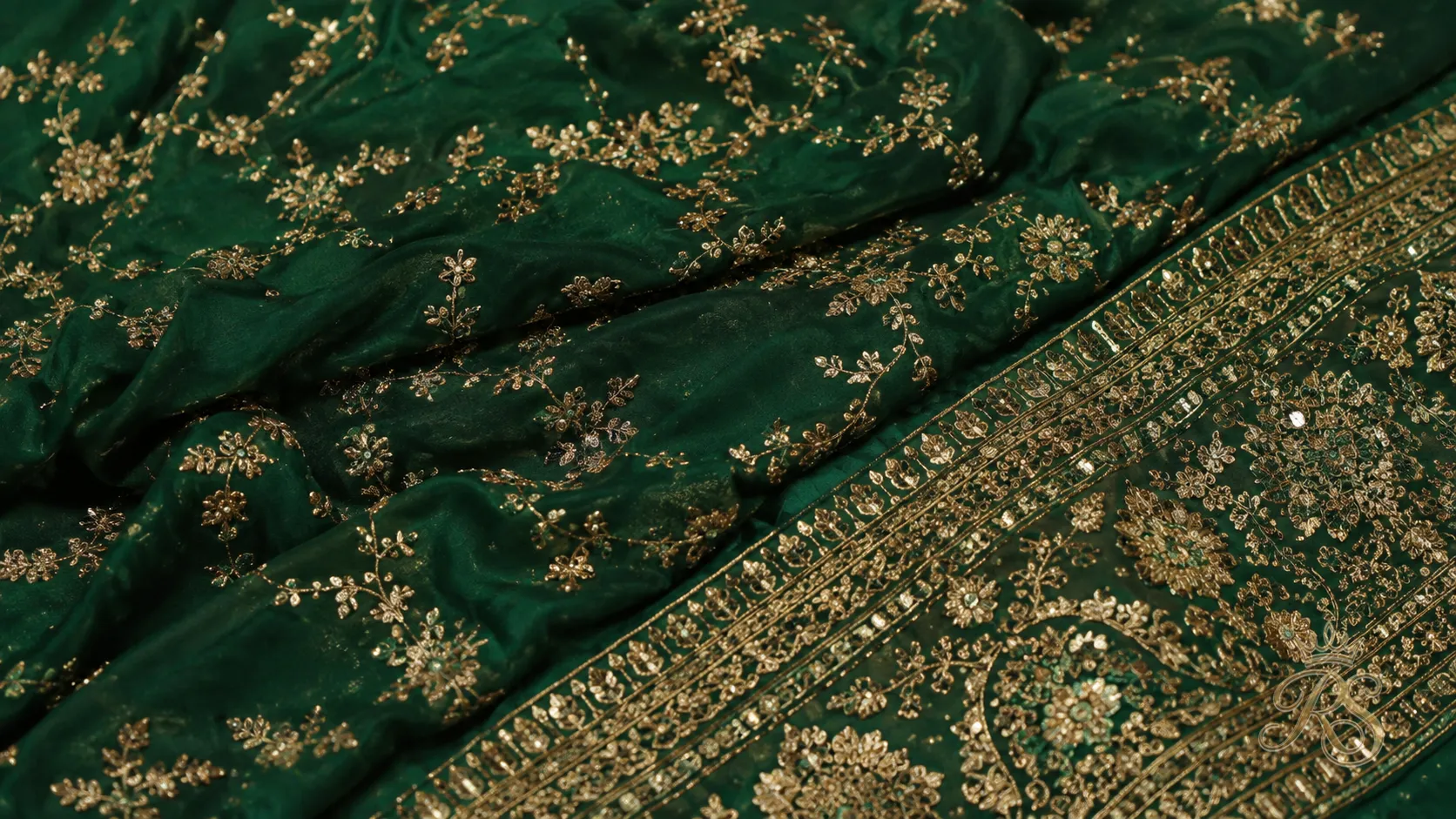 Emerald green couture bridal lehenga fabric with gold embroidery detail
