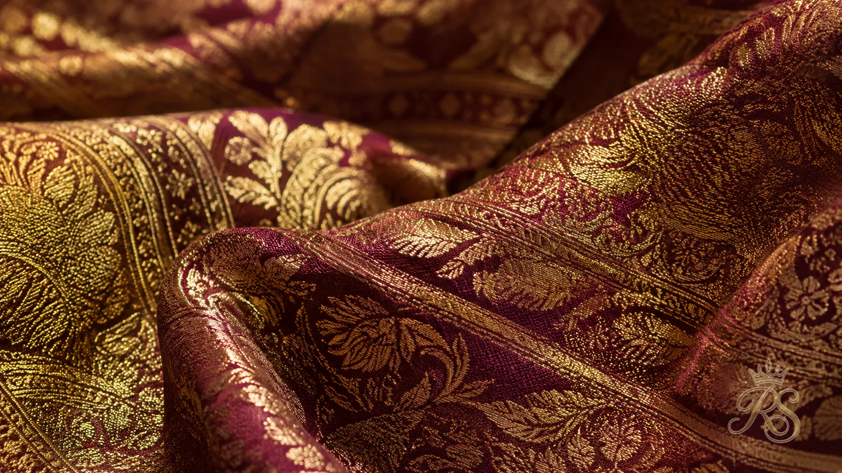 Close-up of custom-woven bridal brocade fabric in gold and burgundy