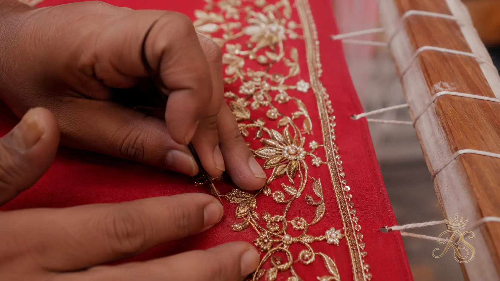Artisan hand-embroidering a bridal lehenga panel with zardozi thread work