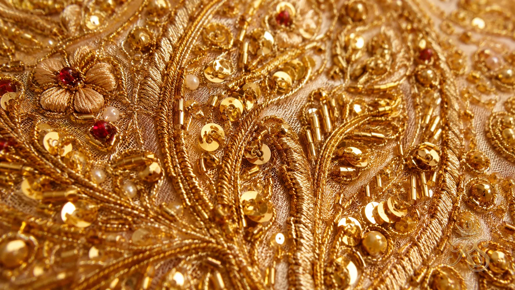 Close-up of zardozi gold thread embroidery on bridal lehenga fabric