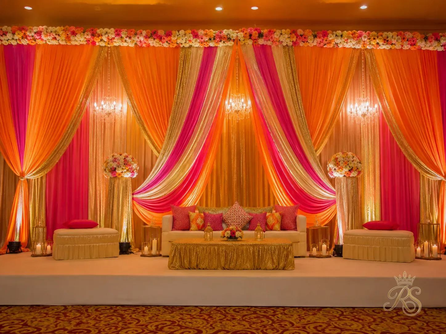 Colourful fabric draping in saffron, pink and gold for a sangeet stage backdrop