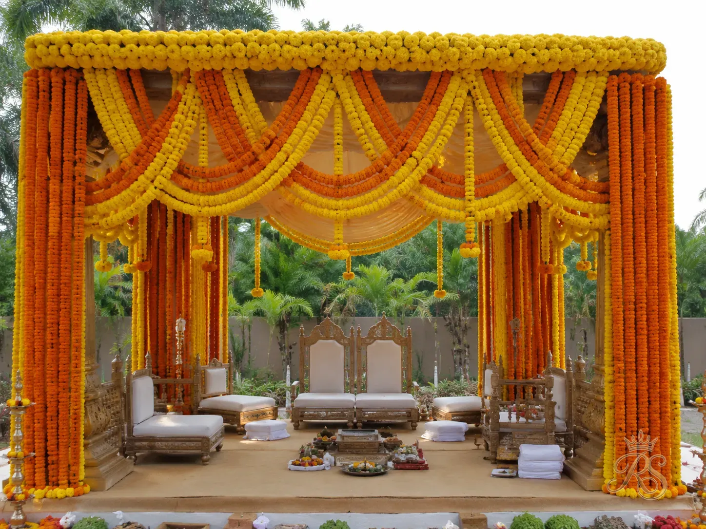 Wedding mandap covered in fresh orange and yellow marigold garlands