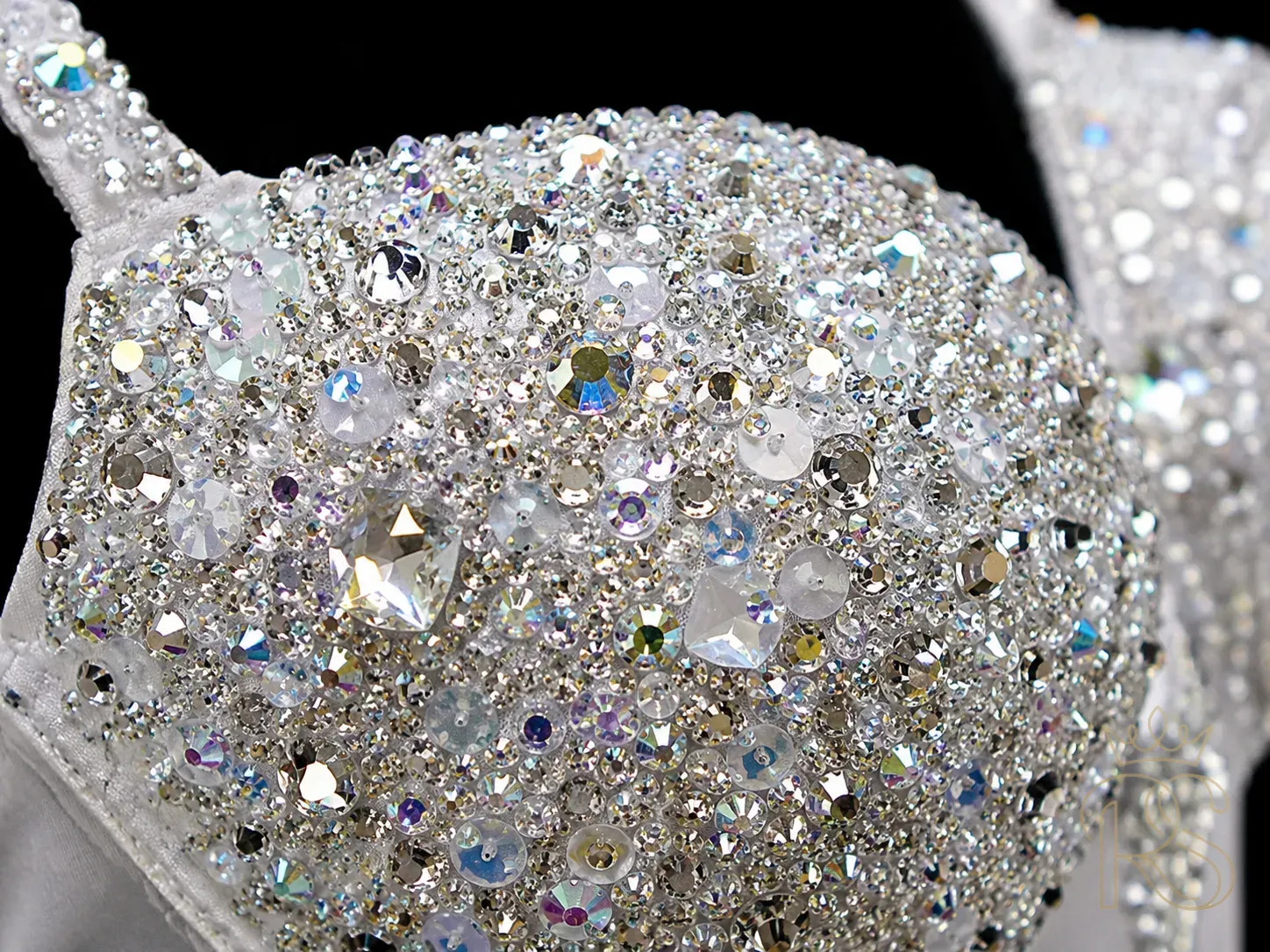Extreme close-up of bridal blouse surface covered in hand-applied Swarovski crystals and iridescent sequins, different sizes catching light from multiple angles, macro photography, black background