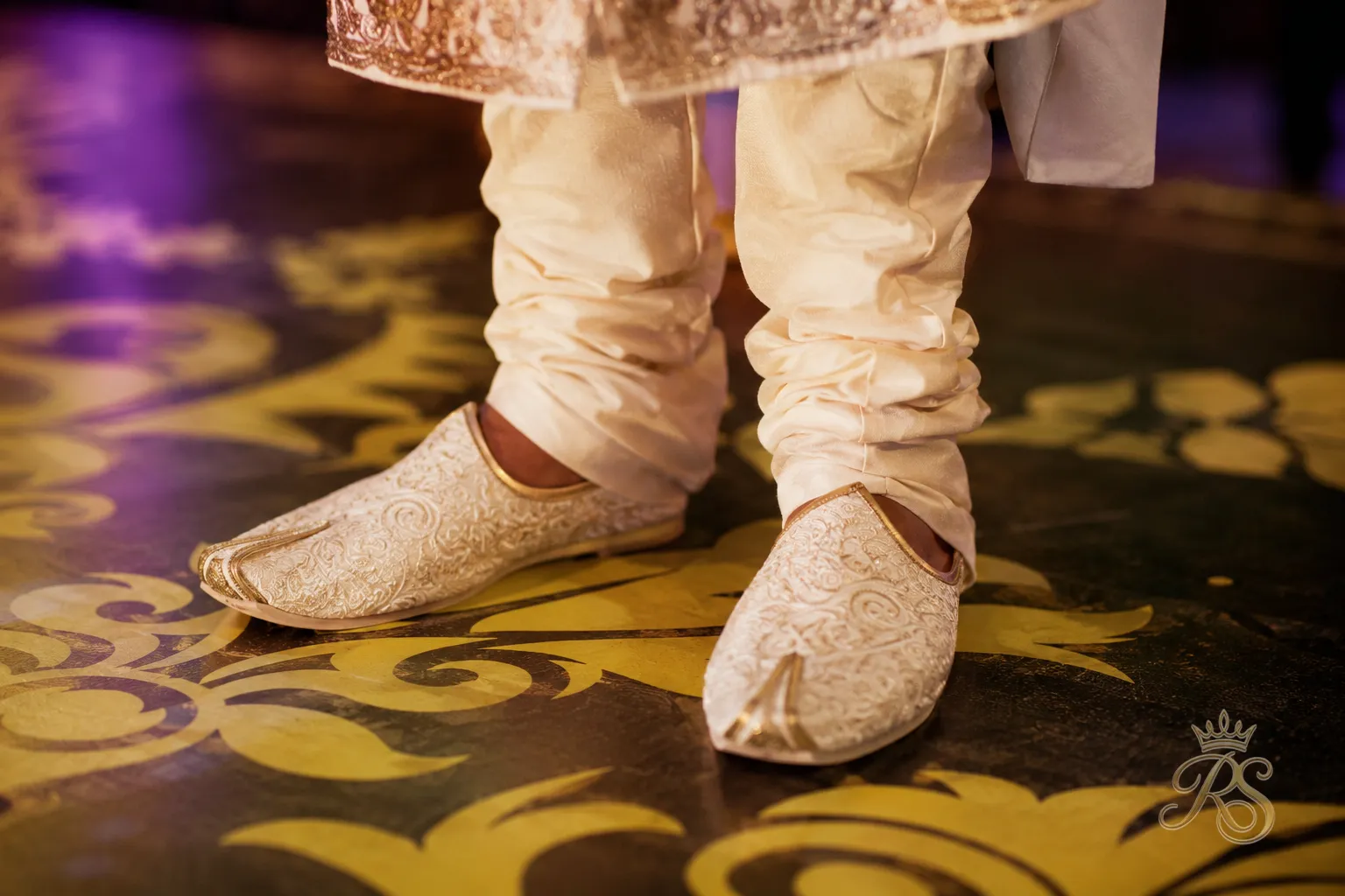 Close-up of traditional embroidered mojari footwear worn by a groom at a sangeet
