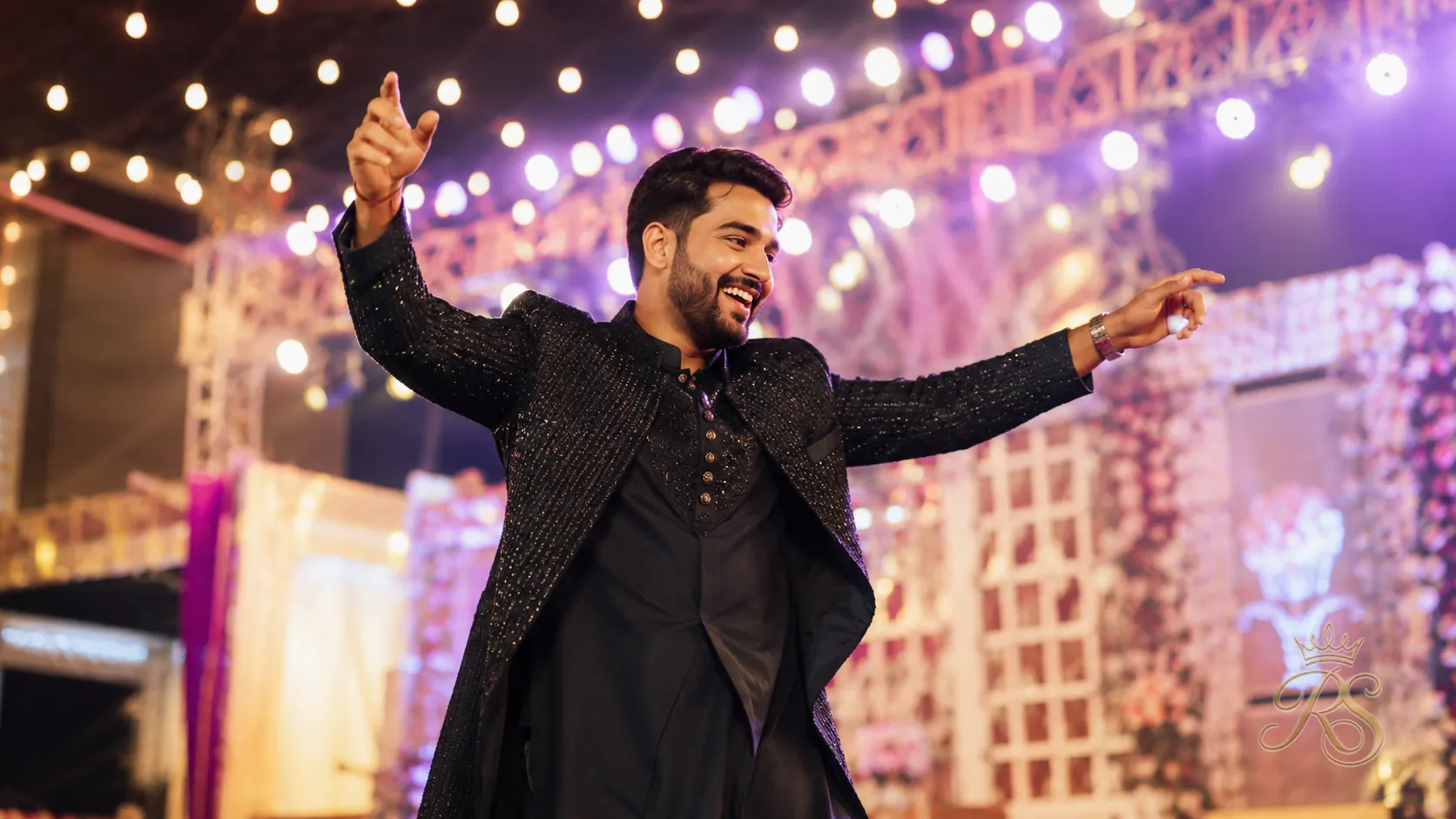 Groom in a stylish Indo-Western sangeet outfit dancing joyfully at a wedding sangeet function