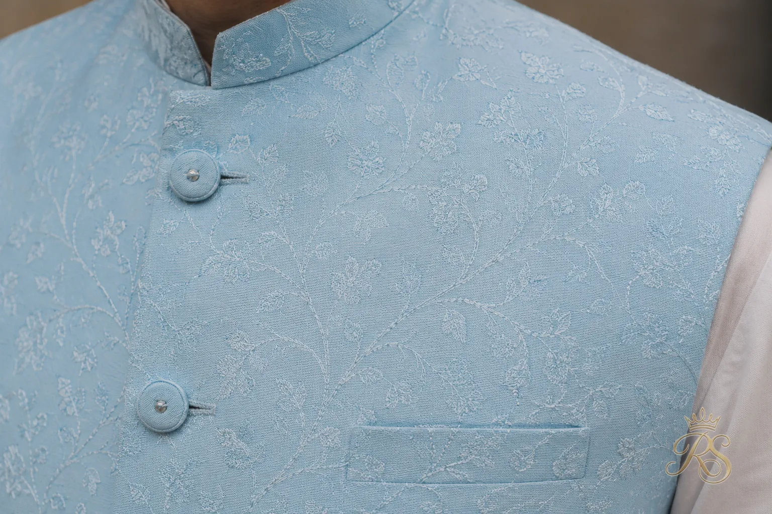 Close-up detail of a pastel Nehru jacket fabric with subtle thread embroidery