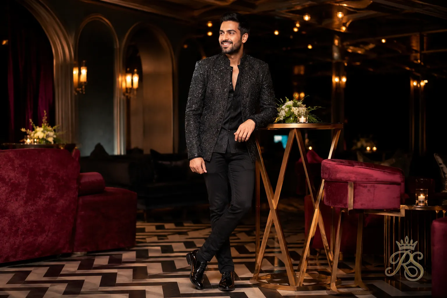 Groom wearing an embellished statement jacket over dark denim for a modern sangeet look