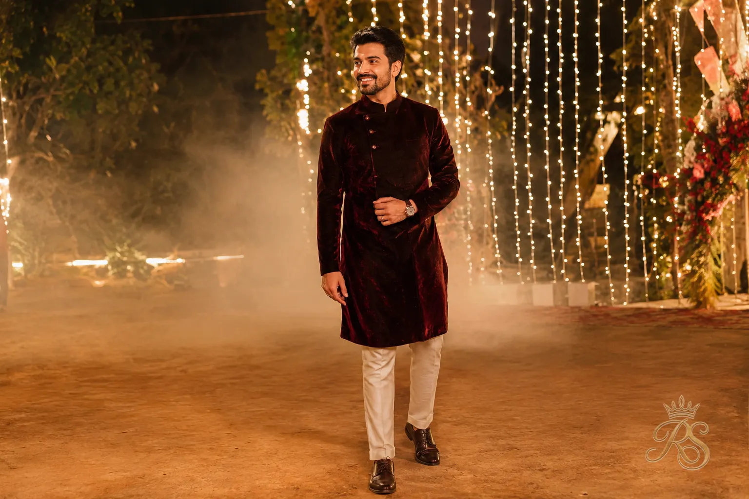 Groom wearing a wine-colored velvet kurta at a winter wedding sangeet function
