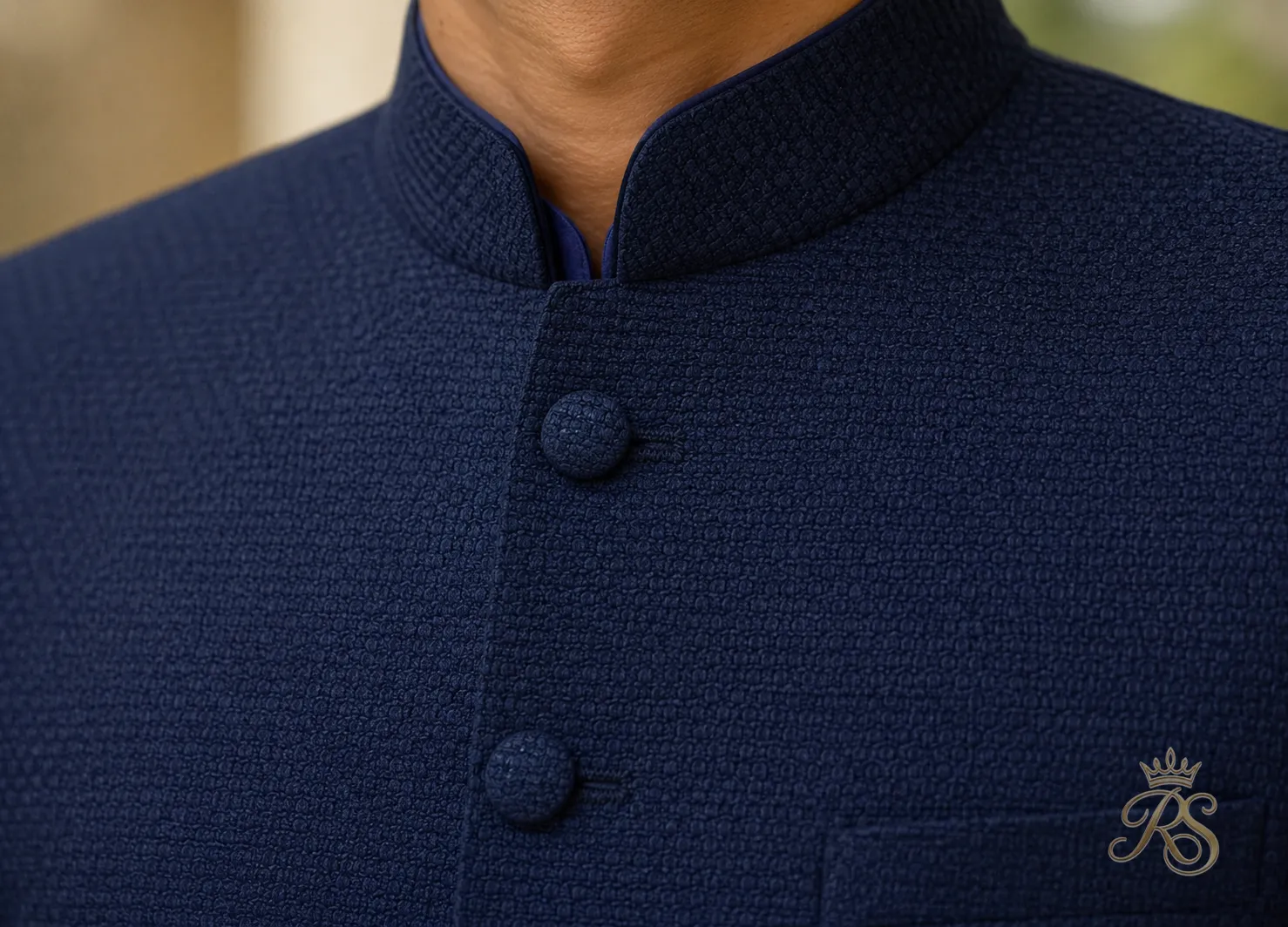 Close-up of a textured navy bandhgala jacket fabric with fabric-covered buttons