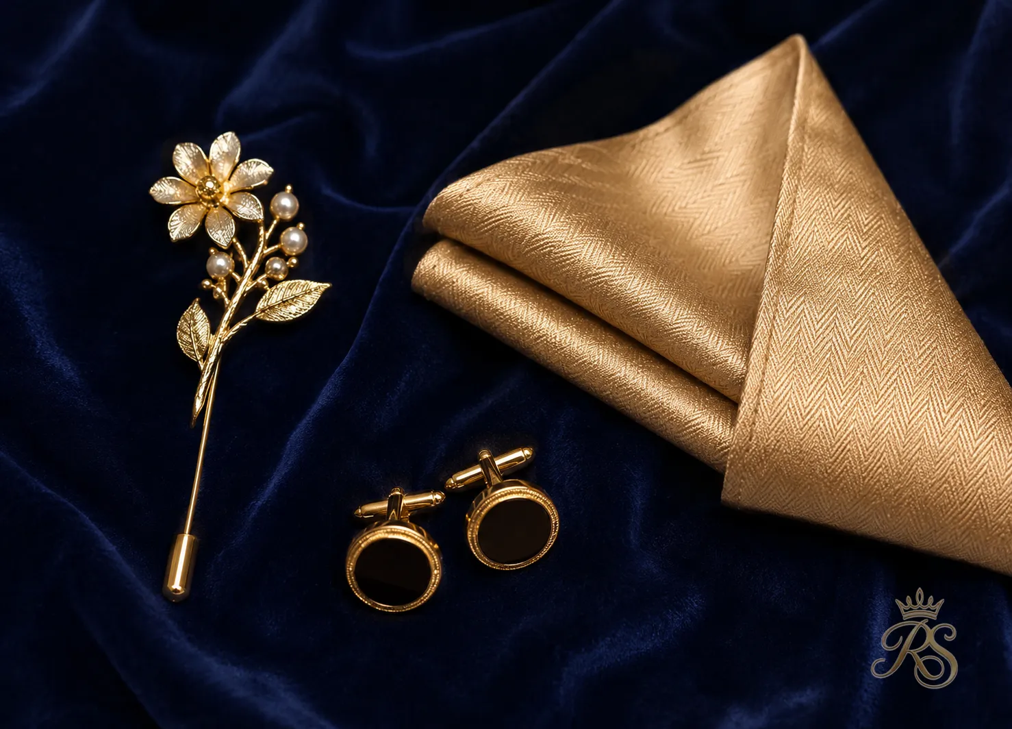 Flatlay of groom wedding accessories including a brooch, pocket square, and cufflinks