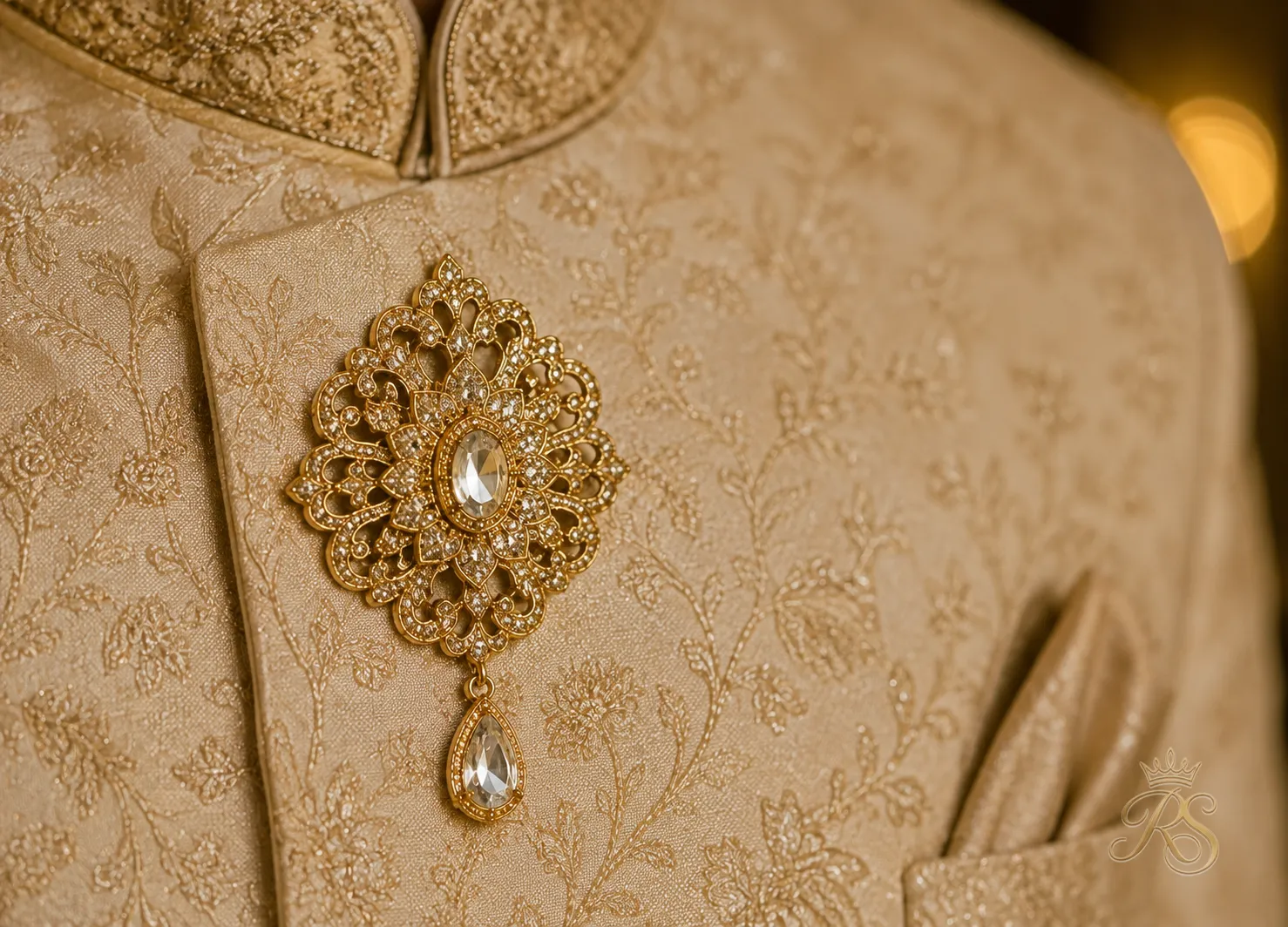 Close-up of a gold brooch pinned to a groom's sherwani lapel