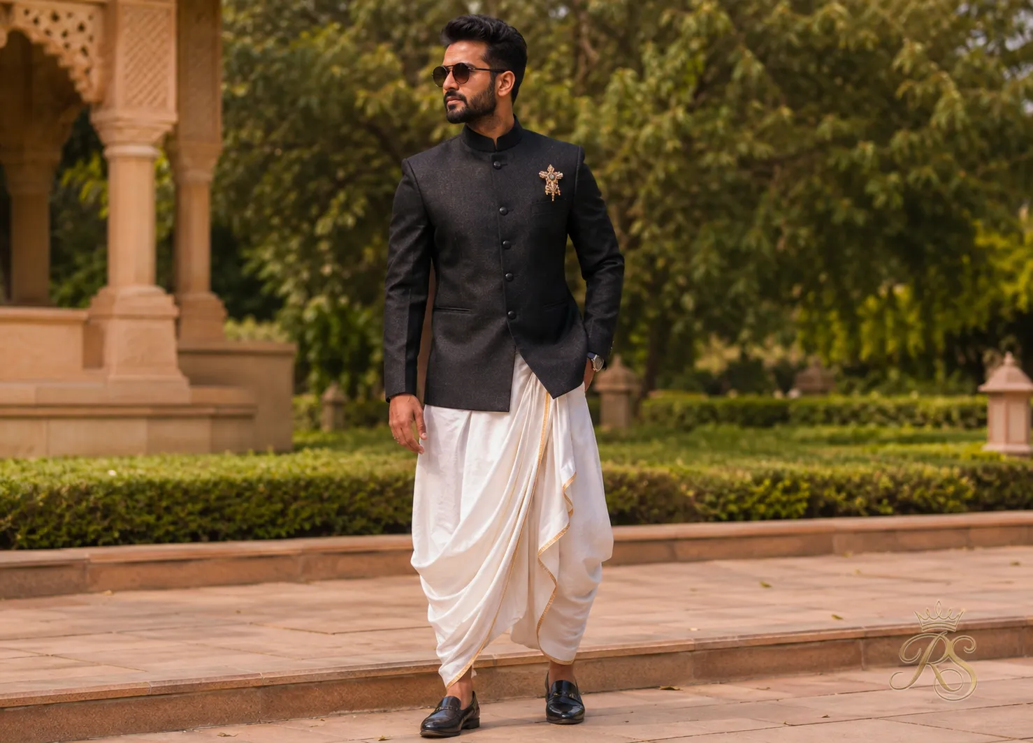 Groom wearing draped dhoti pants with a fitted blazer