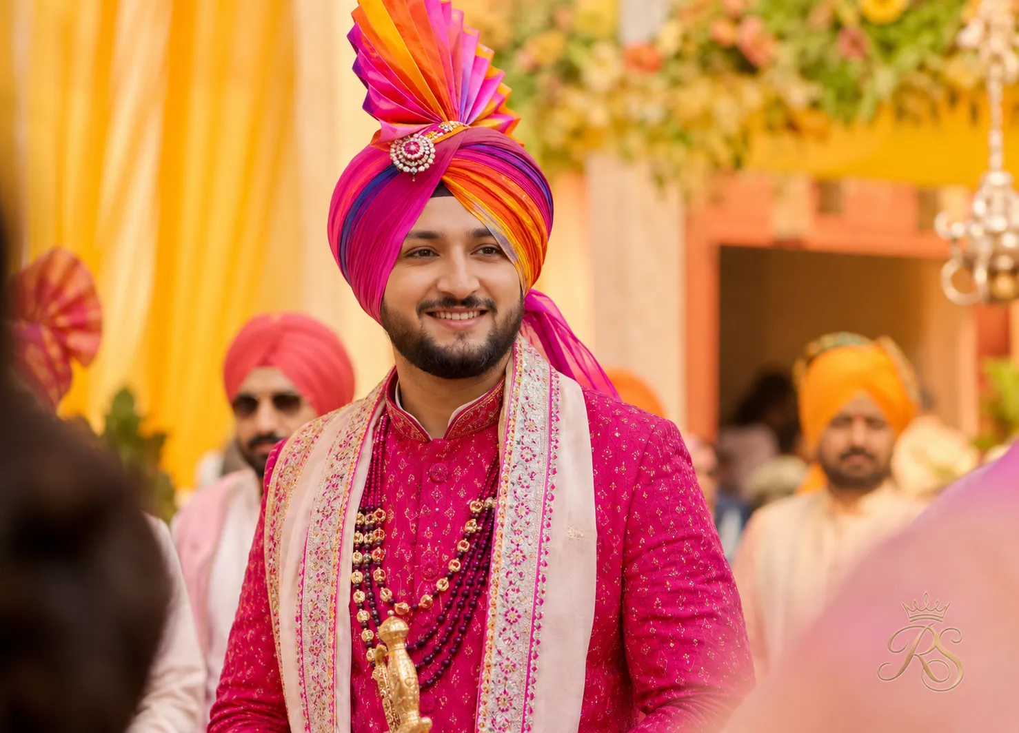 Punjabi groom in a vibrant kurta with a tall colorful pagri turban