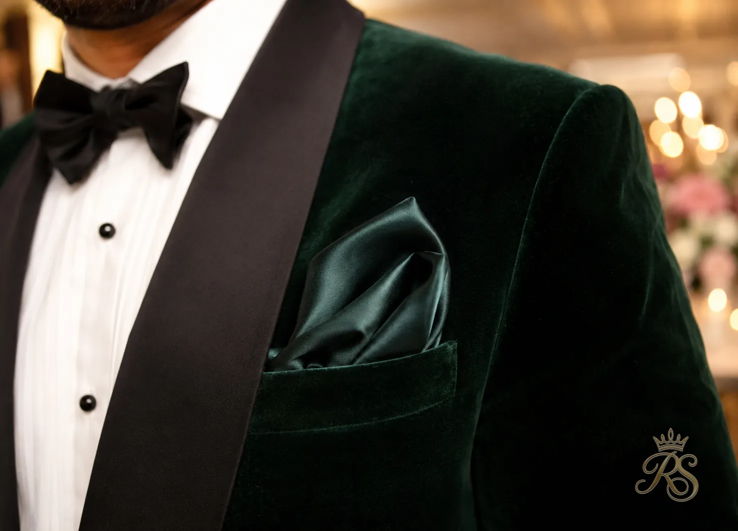Close-up of a groom's velvet dinner jacket lapel and pocket square at reception