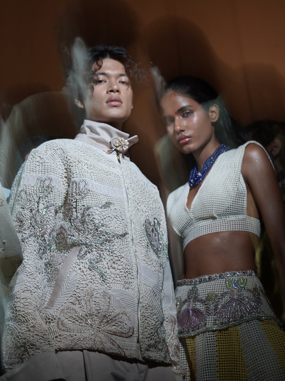 Models backstage for Aisha Rao in a metallic lace jacket and a netted crop top with beaded trim