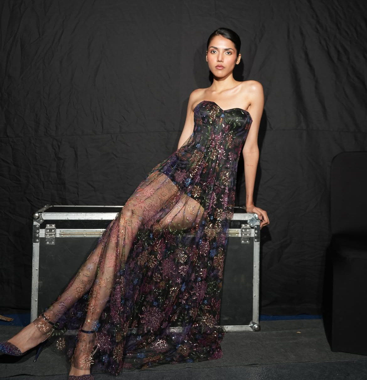 Model backstage in a sheer floral-embroidered gown with a beaded floral tulle skirt