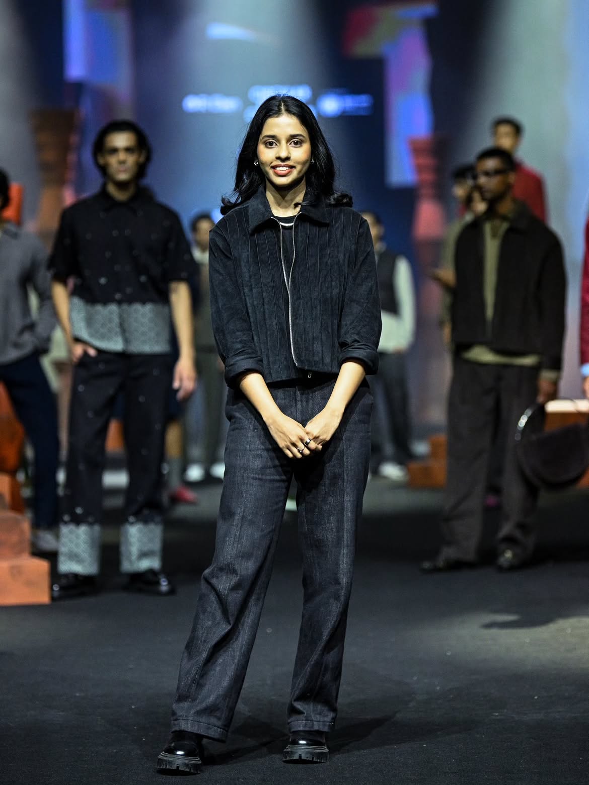 Model walking the runway in a grey trench coat, white shirt, and wrap chambray skirt for R-ELAN CRCLE at Lakmē Fashion Week