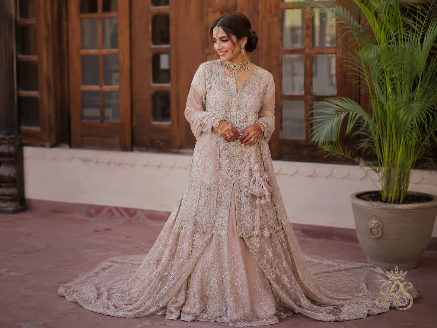 Bride wearing a long-shirt bridal lehenga trend with trail hemline