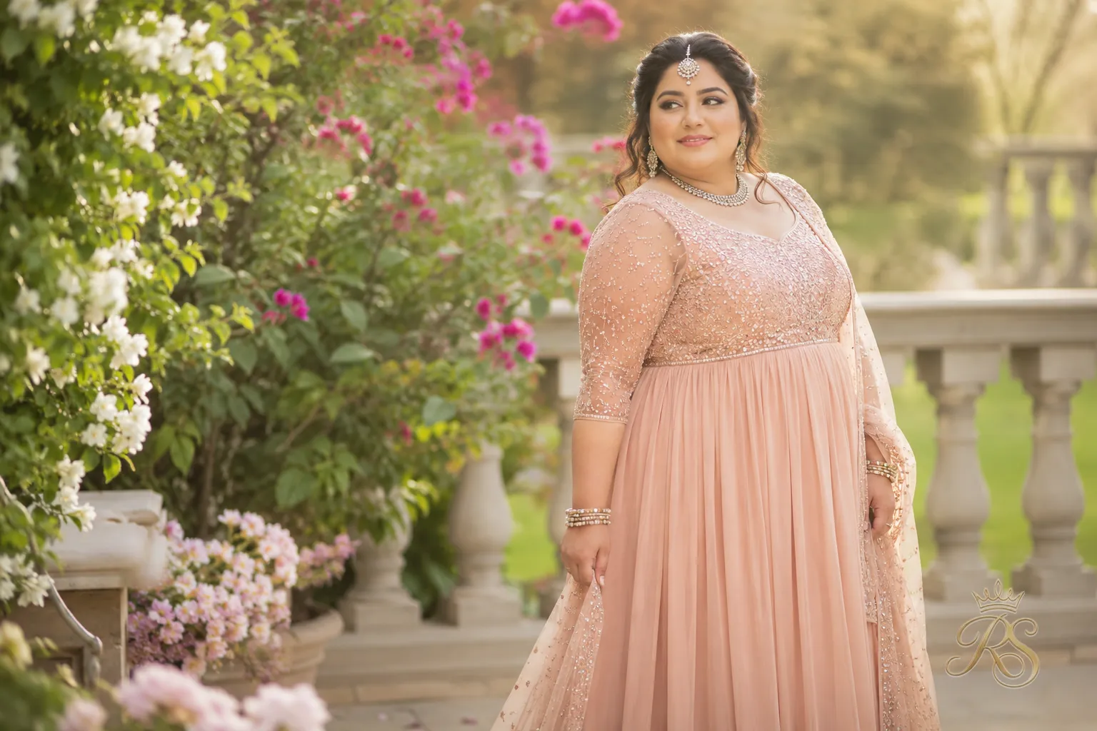 Plus size bride in an empire waist bridal gown with a fitted bodice and flowing skirt