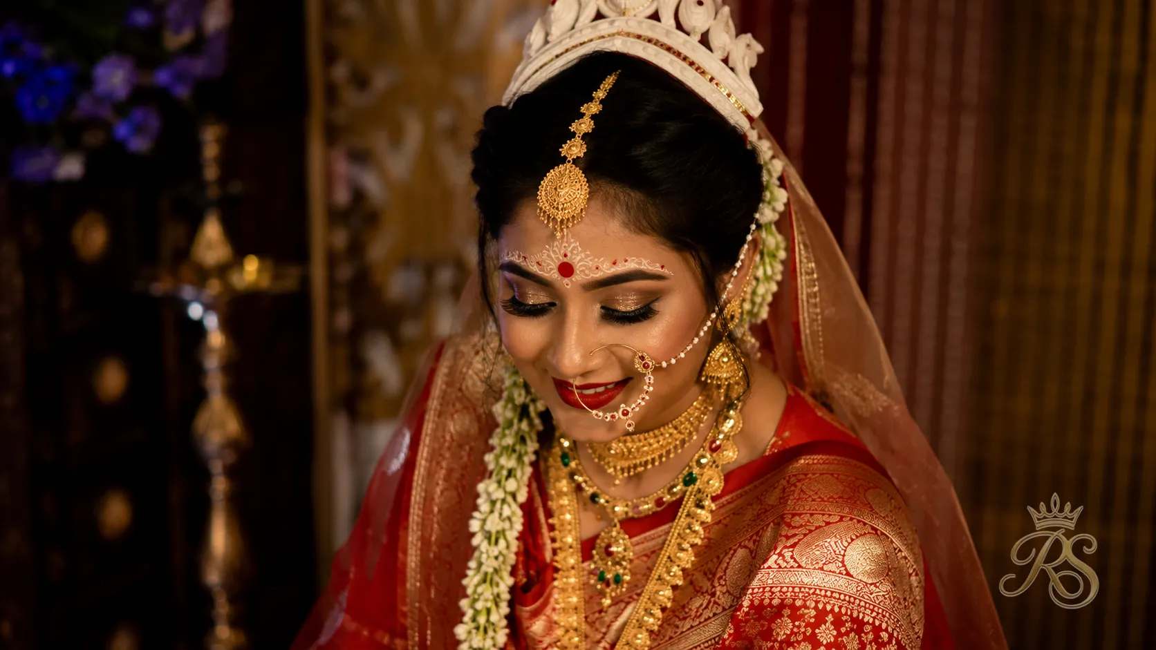 Bengali bride wearing traditional gold jewellery with polki accents