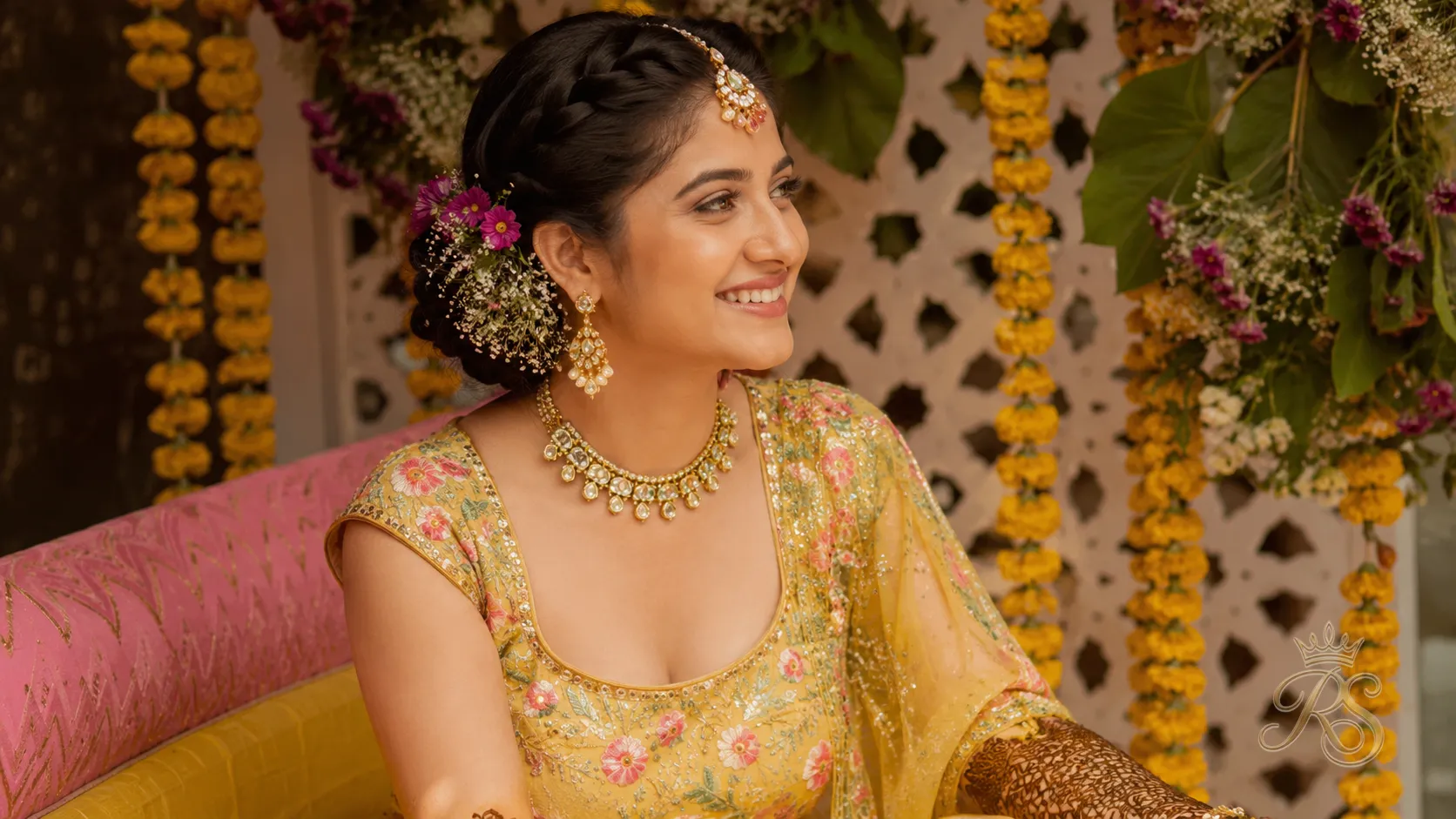 Bride at mehendi ceremony wearing lightweight gold and kundan jewellery