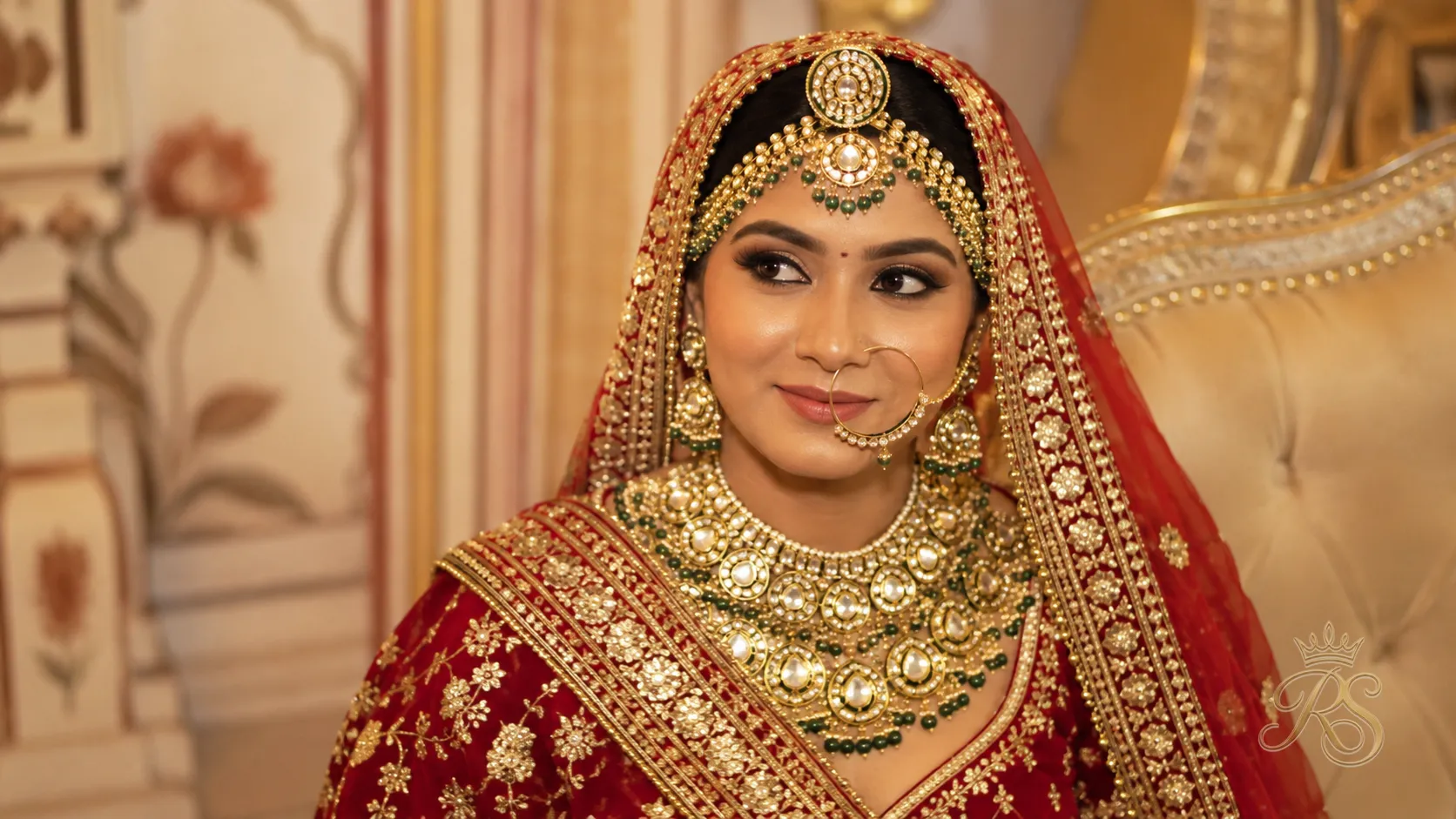 Rajasthani bride wearing a heavy kundan and polki set with borla and rakhdi
