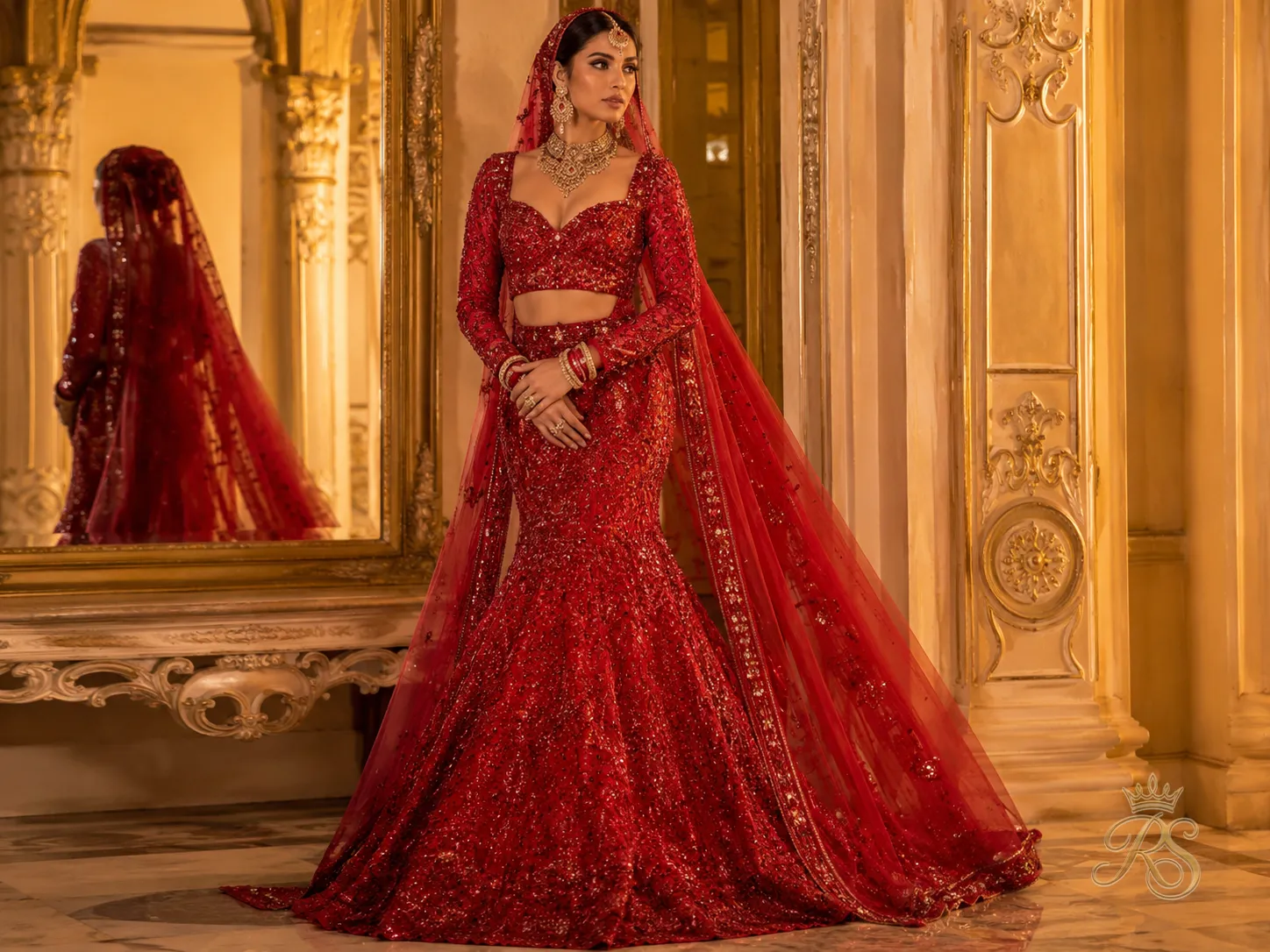 Red mermaid cut bridal lehenga fitted through the hips with a dramatic flare