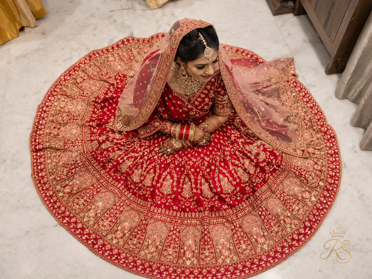 Indian bride in embroidered bridal lehenga photographed from above showing full skirt spread
