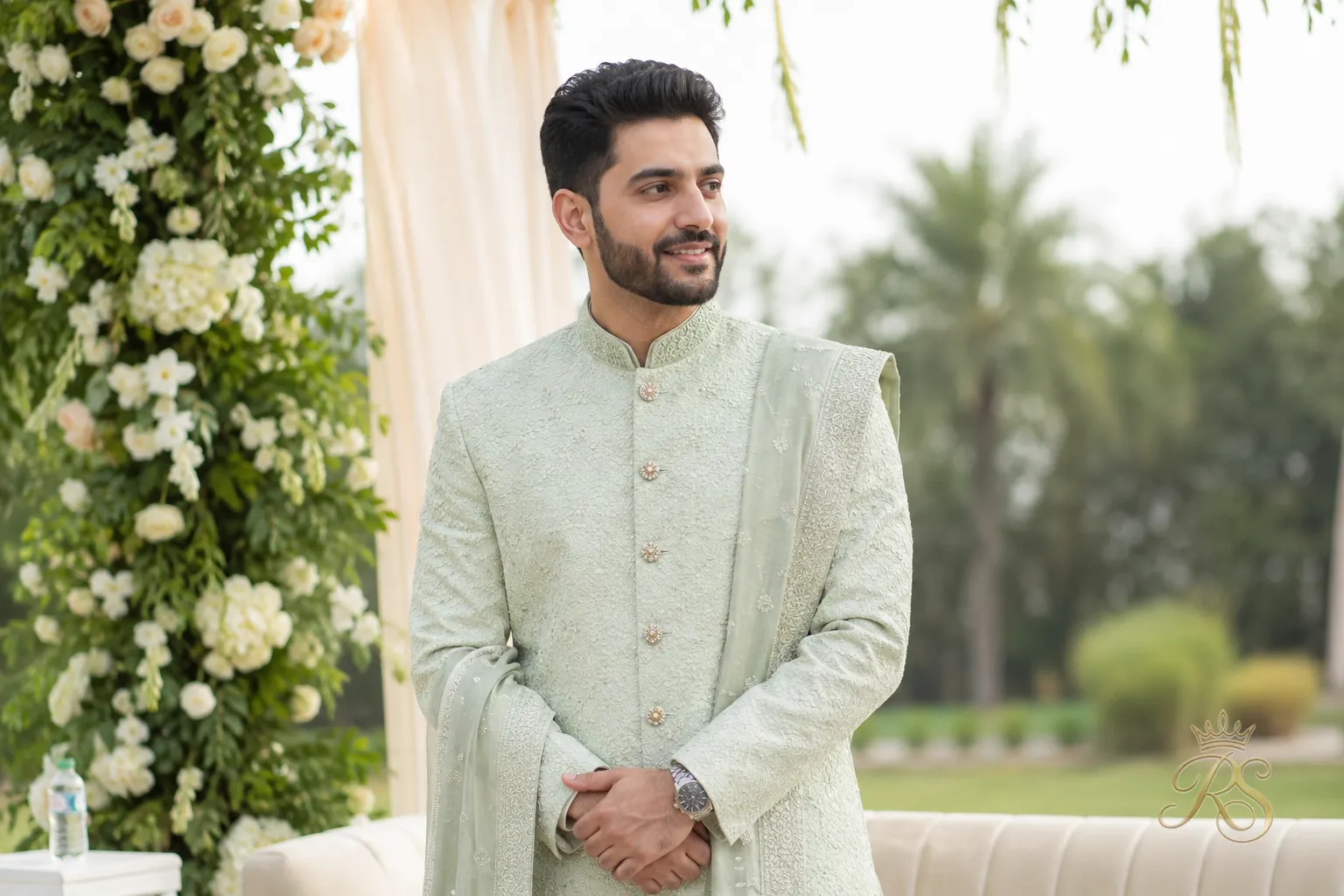 Groom in a pastel sage green sherwani for a daytime wedding ceremony