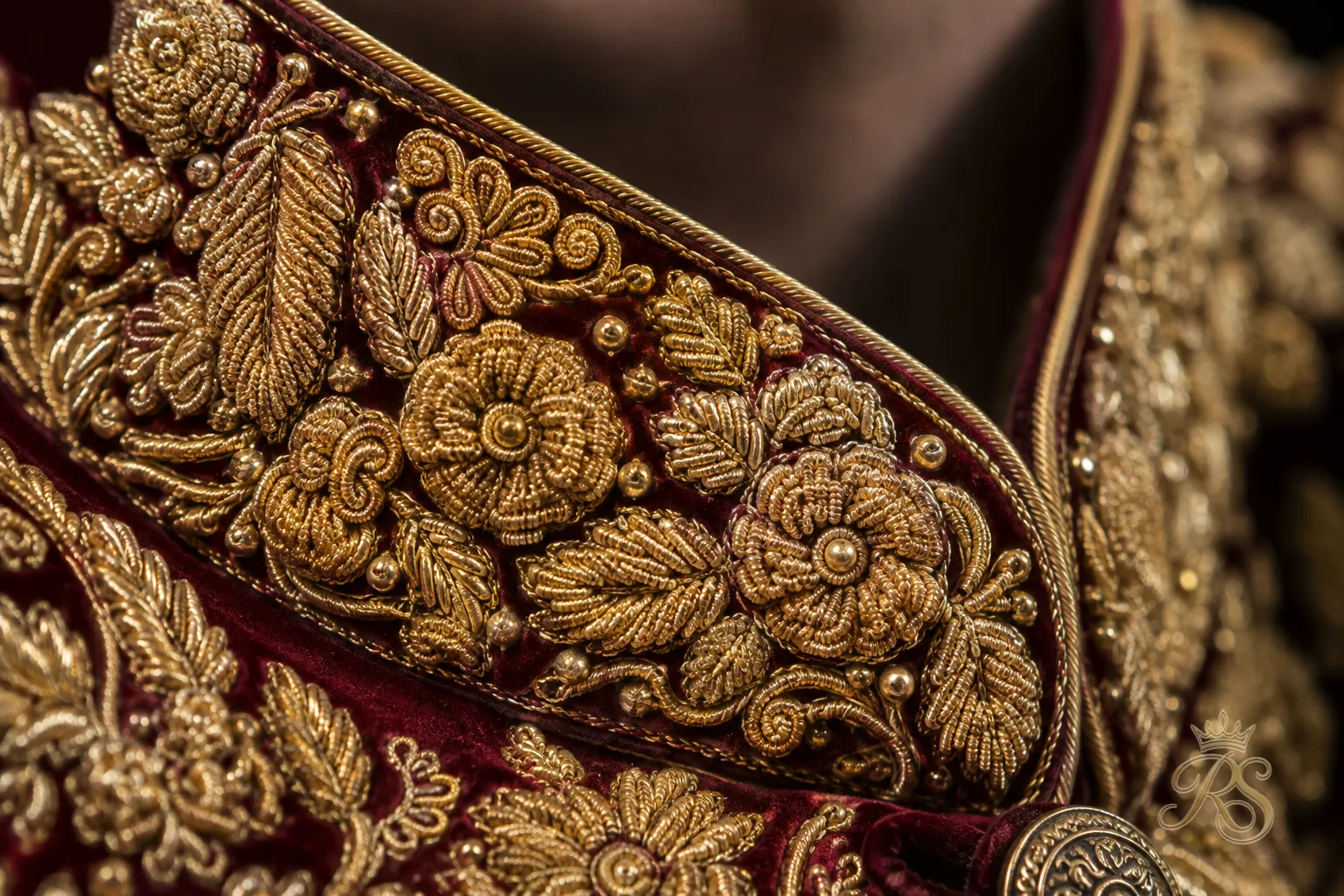 Close-up of intricate zardozi embroidery on a groom's wedding sherwani collar